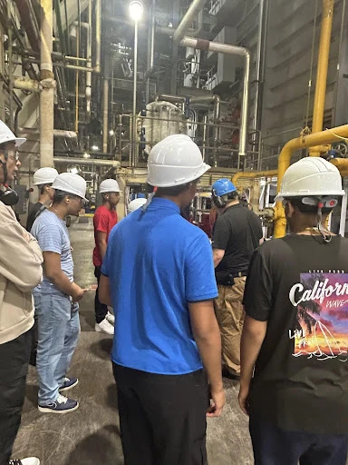 High school students in hard hats touring an energy facility
