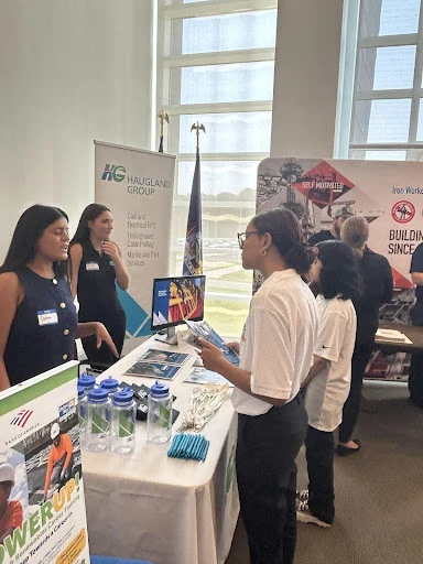 High school students talking with energy professionals at a career booth